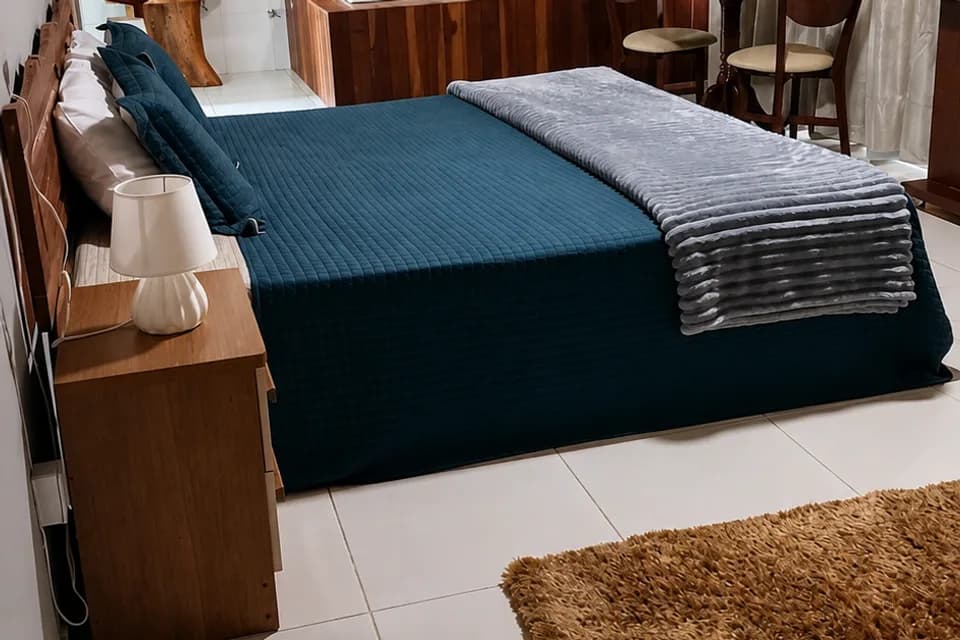 Quarto da Suíte Araucária, com cama de casal e a banheira de hidromassagem ao fundo