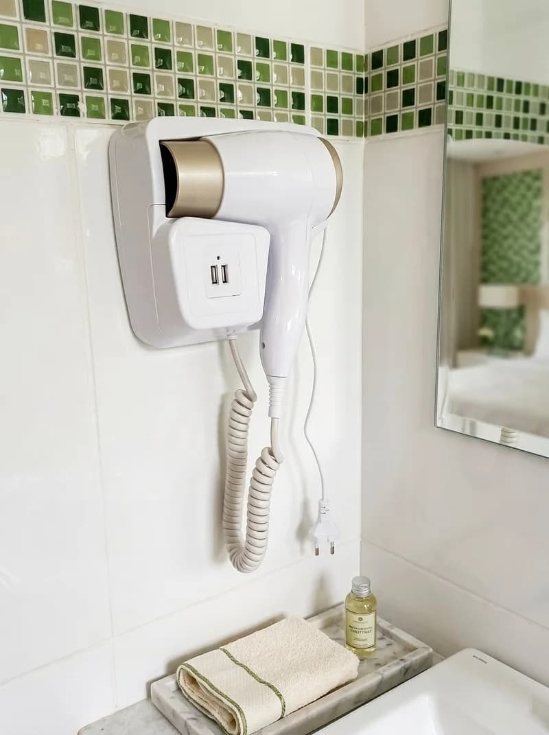 Hairdryer and towels in the Hortênsias Suite bathroom